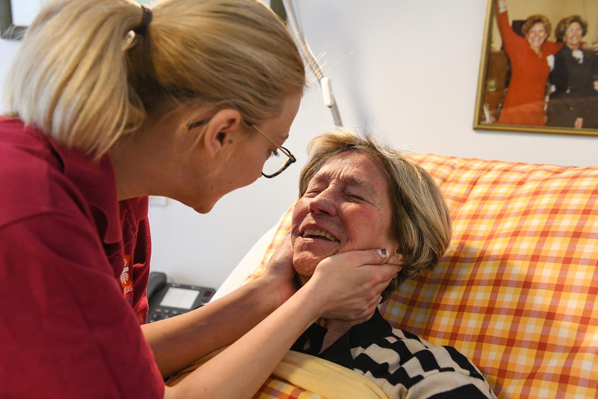Pflegerin gibt einer Seniorin Zuwendung